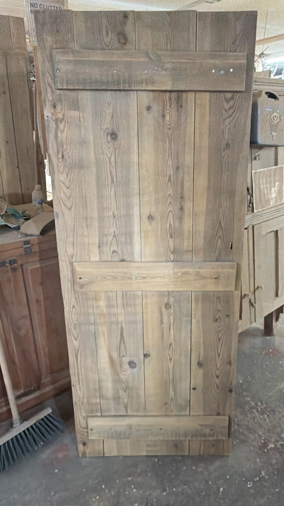 Back of a reclaimed barn door stripped to bare timber showing original boards and ledges